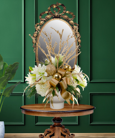 24 Karat Christmas luxury flower arrangement with white lilies, white hydrangeas, gold ornaments, gilded branches, and gold ribbon in a gold vase