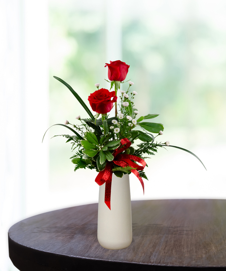 Valentine Bud Vase with six red roses, white baby's breath, and a red glitter ribbon in a tall white ceramic vase.