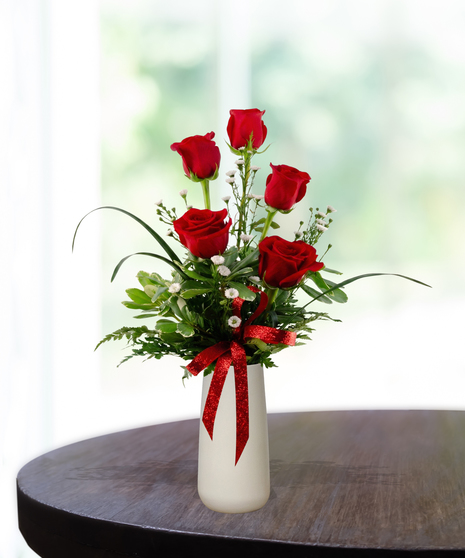 Valentine Bud Vase with six red roses, white baby's breath, and a red glitter ribbon in a tall white ceramic vase.