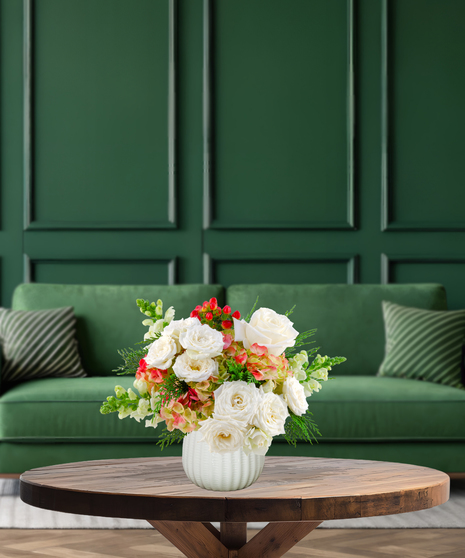 Berry Merry fresh Christmas flower arrangement with white roses, green and pink hydrangeas, red hypericum berries, and green Bells of Ireland in a textured white vase