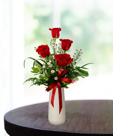Valentine Bud Vase with six red roses, white baby's breath, and a red glitter ribbon in a tall white ceramic vase.