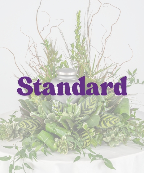 Green cremation arrangement with natural branches and urn space – Sportsman’s Paradise Funeral Suite by Billy Heroman’s