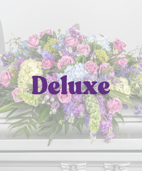 Bold Spring Mix casket cover with pink roses, blue hydrangeas, and purple spring flowers from Billy Heroman’s in Baton Rouge, LA