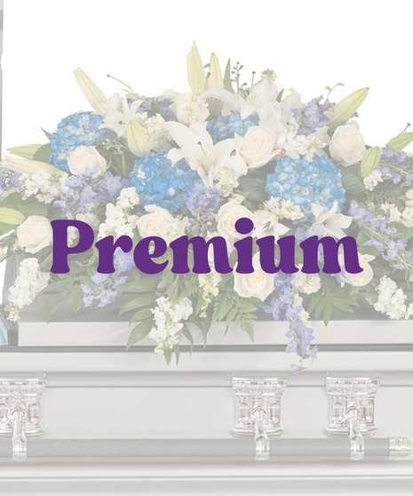 Blue and white casket cover with hydrangea, lilies, roses, and stock on silver casket