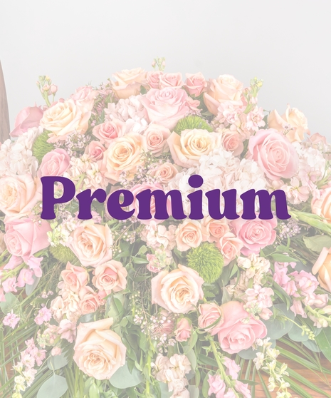 Peach and pink rose casket cover with hydrangea and snapdragons on wood casket