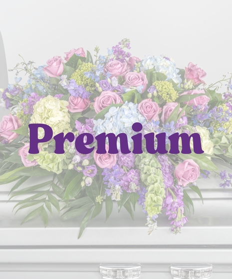 Bold Spring Mix casket cover with pink roses, blue hydrangeas, and purple spring flowers from Billy Heroman’s in Baton Rouge, LA
