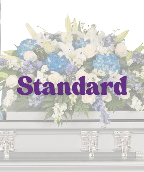 Blue and white casket cover with hydrangea, lilies, roses, and stock on silver casket
