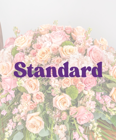 Peach and pink rose casket cover with hydrangea and snapdragons on wood casket