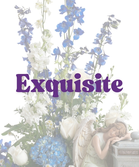Cremation arrangement featuring white roses, blue hydrangea, and a sleeping angel figurine next to a stone urn with engraved message