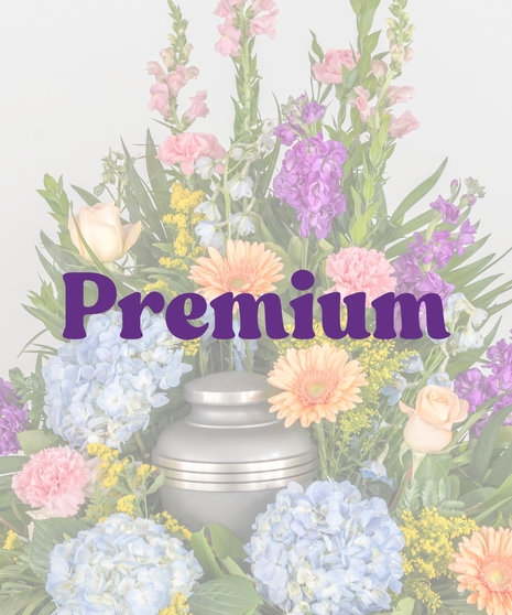 Colorful cremation urn flower arrangement with blue hydrangea, gerbera daisies, and spring blooms from Billy Heroman’s Florist in Baton Rouge