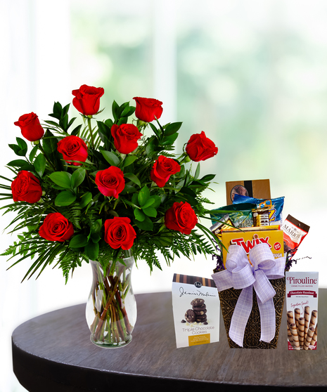 Sugar & Blooms Delight featuring one or two dozen roses (choice of color) in a vase with a gourmet snack basket including cookies, chocolates, and sweets.