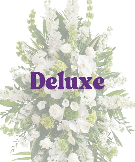 Elegant White Funeral Standing Spray with white roses, orchids, lilies, and bells of Ireland on a wooden easel
