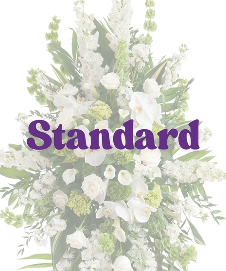 Elegant White Funeral Standing Spray with white roses, orchids, lilies, and bells of Ireland on a wooden easel