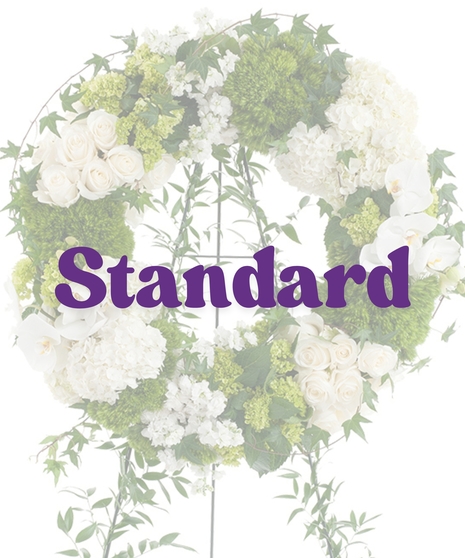 Elegant White Wreath Stand with white roses, hydrangeas, orchids, and green moss on a vine-covered easel