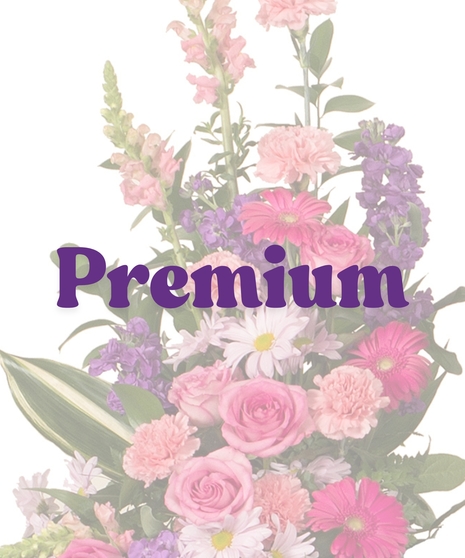 Feminine cremation sidepiece with pink roses, carnations, gerbera daisies, lavender daisies, and greenery