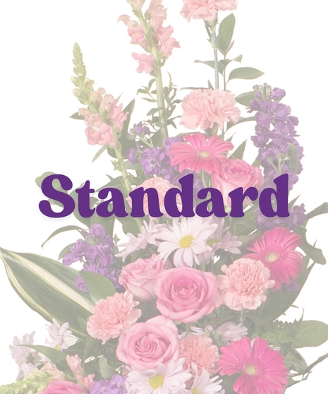 Feminine cremation sidepiece with pink roses, carnations, gerbera daisies, lavender daisies, and greenery