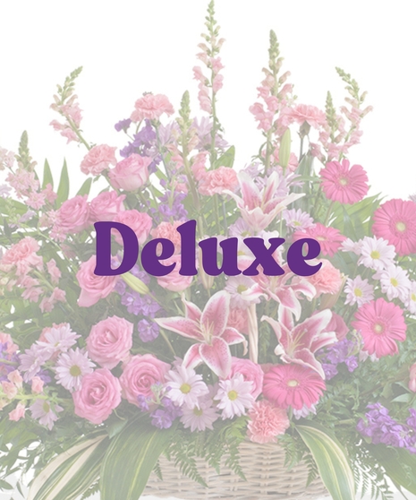Feminine floor basket with pink roses, lilies, gerbera daisies, lavender daisies, and greenery in a wicker basket