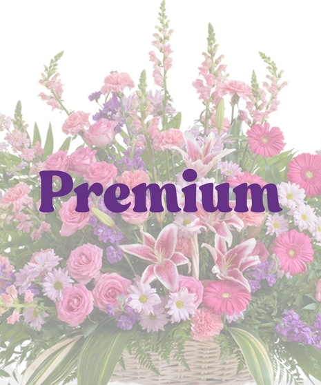 Feminine floor basket with pink roses, lilies, gerbera daisies, lavender daisies, and greenery in a wicker basket