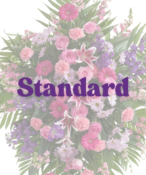 Feminine standing spray with stargazer lilies, roses, carnations, gerbera daisies, snapdragons, and purple stock on an easel