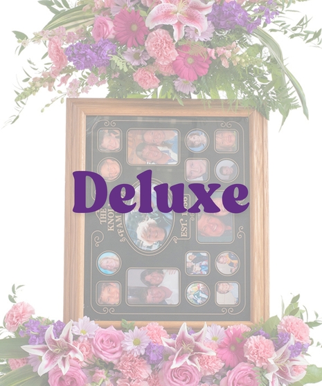 Floral picture frame stand with pink roses, carnations, lilies, daisies, and greenery surrounding a memory collage