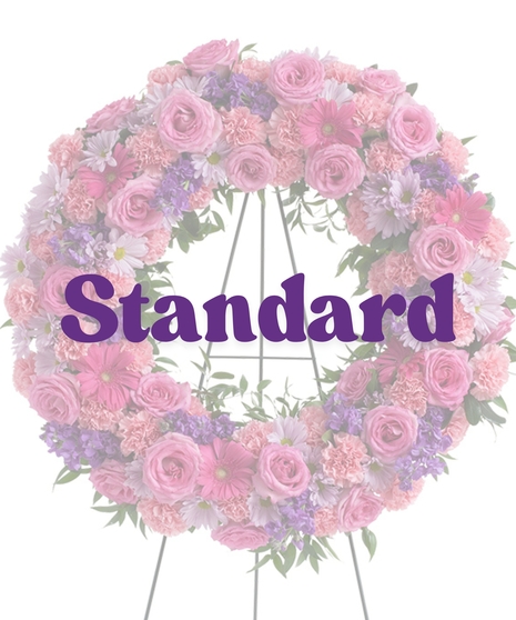 Feminine Funeral Wreath with pink roses, carnations, purple daisies, stock, and gerbera on a standing easel