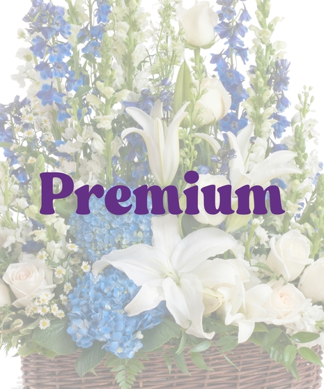 Sympathy floor arrangement in blue and white with lilies, hydrangea, roses, and snapdragons in a brown basket