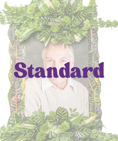 Floral photo frame tribute with croton leaves, green foliage, and tropical accents on an easel from Billy Heroman’s in Baton Rouge