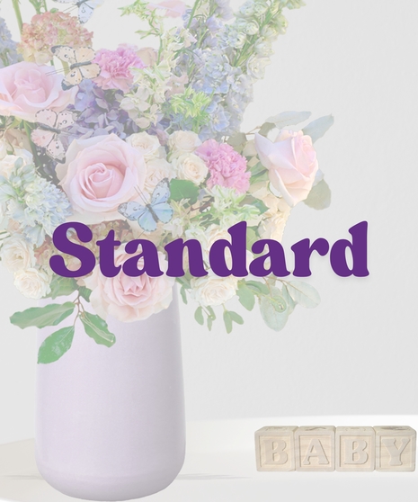 Butterfly Kisses signature flower arrangement by Billy Heroman’s, featuring a mix of pink flowers and blue hydrangeas, perfect for a new baby or mother.