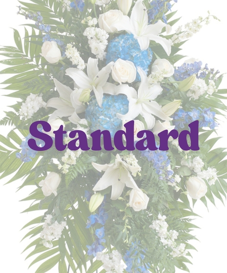Standing funeral spray with blue hydrangea, white lilies, ivory roses, and greenery on easel
