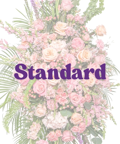 Tall funeral standing spray with pink roses, snapdragons, carnations, and lush greenery on an easel – Tender Blush Suite by Billy Heroman’s