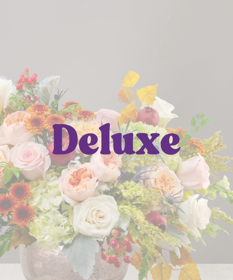 Gemma fall flower arrangement featuring cream and peach roses, hydrangea, berries, eryngium, and pomegranates in a copper vase