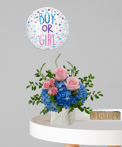 Pink roses and blue hydrangeas in a white textured vase with a 