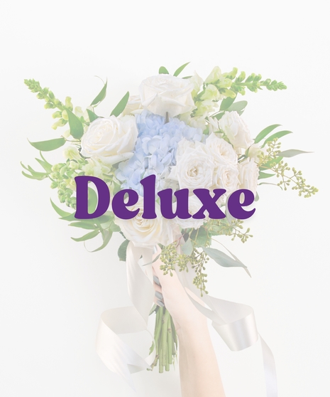 Glass Slippers handheld bouquet with ivory roses, blue hydrangea, and white snapdragons tied with satin ribbon