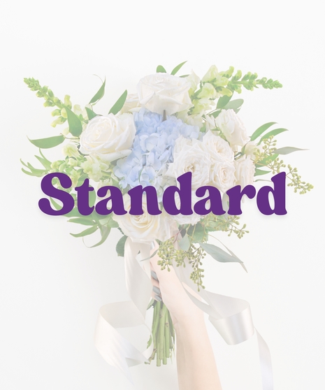 Glass Slippers handheld bouquet with ivory roses, blue hydrangea, and white snapdragons tied with satin ribbon