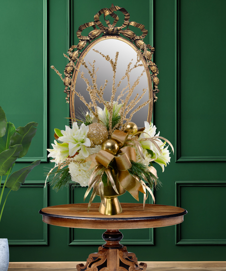 24 Karat Christmas luxury flower arrangement with white lilies, white hydrangeas, gold ornaments, gilded branches, and gold ribbon in a gold vase