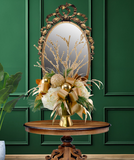 24 Karat Christmas luxury flower arrangement with white lilies, white hydrangeas, gold ornaments, gilded branches, and gold ribbon in a gold vase