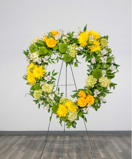 Golden Horizon heart-shaped funeral stand with yellow roses, mums, and white alstroemeria from Billy Heroman’s in Baton Rouge