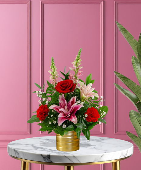 Heart Throb luxury Valentine's arrangement with red roses, pink-tipped lilies, red and pink carnations, and white baby's breath in a ribbed gold metallic vase.