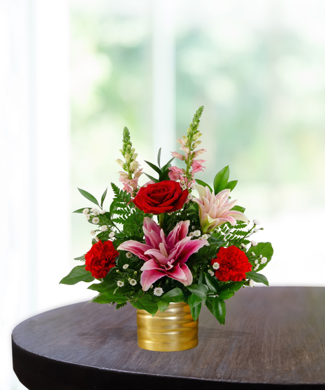 Sugar & Spice flower arrangement featuring red roses, pink lilies, red carnations, and pink snapdragons in a luxury gold ribbed vase