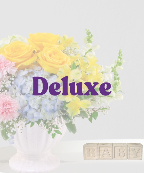 Heaven Sent flower arrangement with yellow roses, blue hydrangeas, pink carnations, and alstroemeria in a cream pedestal vase for a baby shower or gender-neutral gift