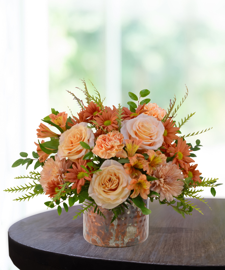 Just Peachy flower arrangement with peach roses, orange carnations, mums, and alstroemeria in a hammered copper vase.
