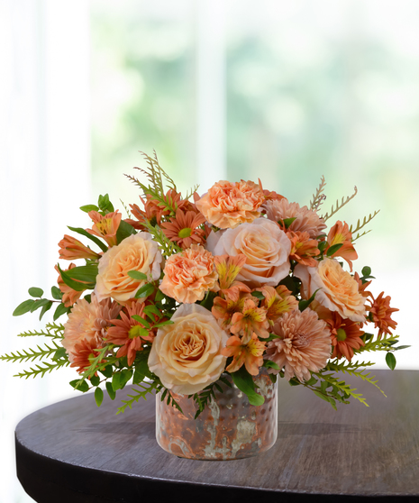 Just Peachy flower arrangement with peach roses, orange carnations, mums, and alstroemeria in a hammered copper vase.