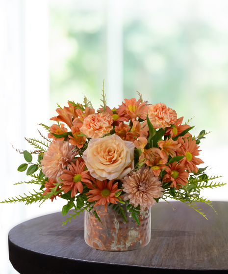 Just Peachy flower arrangement with peach roses, orange carnations, mums, and alstroemeria in a hammered copper vase.