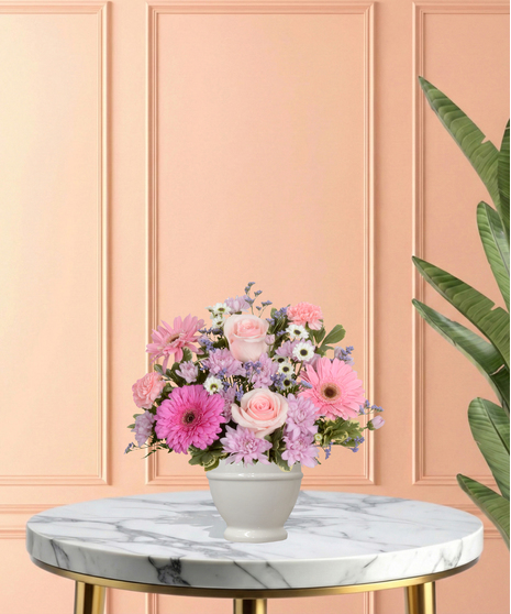 High Tea Blooms Easter floral arrangement featuring pink roses, gerbera daisies, chrysanthemums, pink carnations, and white button mums in a classic white pedestal vase