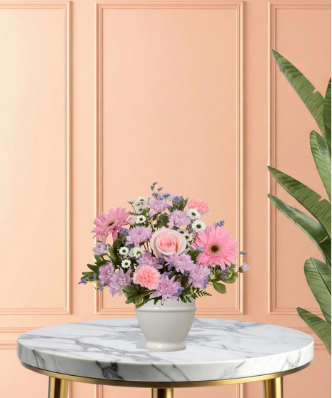 High Tea Blooms Easter floral arrangement featuring pink roses, gerbera daisies, chrysanthemums, pink carnations, and white button mums in a classic white pedestal vase