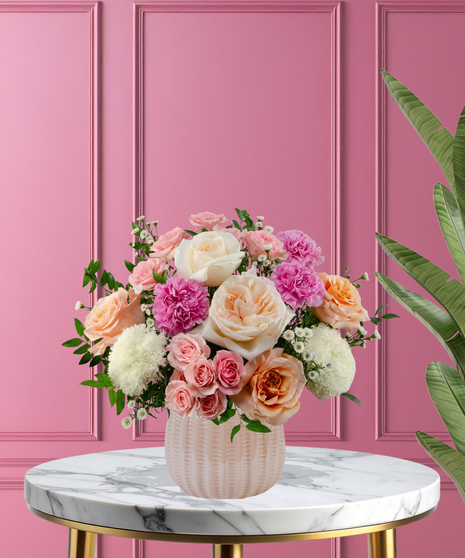 Hopeless Romantic luxury Valentine's arrangement with garden roses,  pink carnations, and lush greenery in a pearl pink ceramic vase.