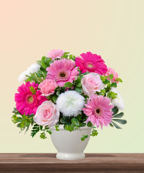 Love You Bunches floral arrangement with pink gerbera daisies, roses, carnations, and white mums in a white vase – cheerful bouquet for Mother’s Day.