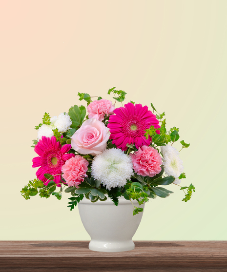 Love You Bunches floral arrangement with pink gerbera daisies, roses, carnations, and white mums in a white vase – cheerful bouquet for Mother’s Day.