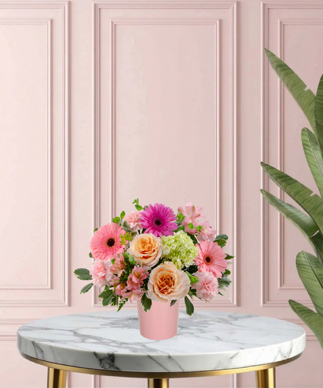 To Mom, With Love Mother's Day flower arrangement featuring peach roses, gerbera daisies, lime-green mini hydrangeas, and pink carnations in a matte pink vase.