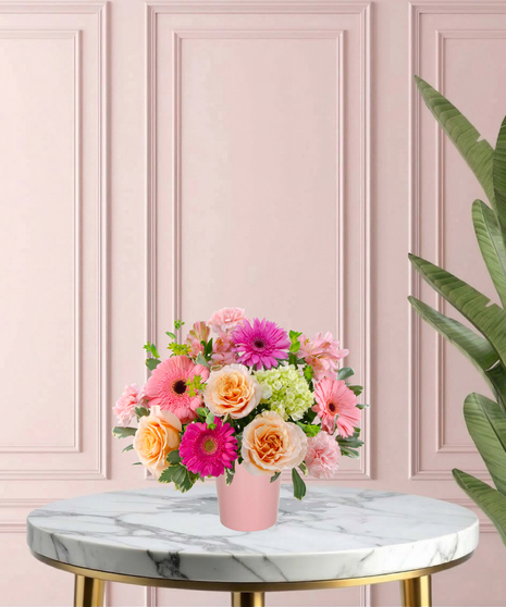 To Mom, With Love Mother's Day flower arrangement featuring peach roses, gerbera daisies, lime-green mini hydrangeas, and pink carnations in a matte pink vase.